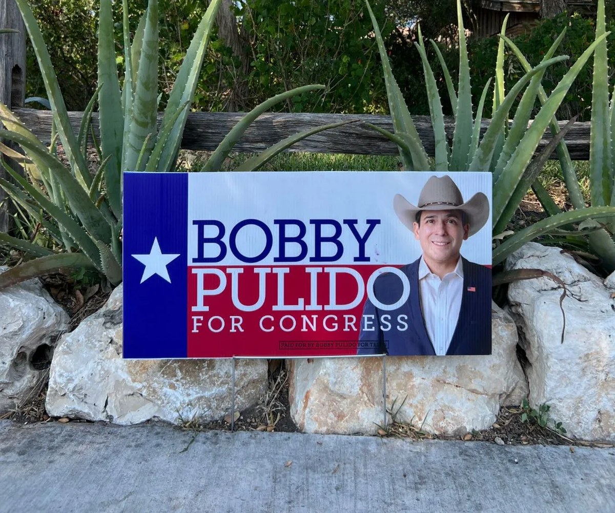A Bobby Pulido for Congress yard sign staked in a front yard.